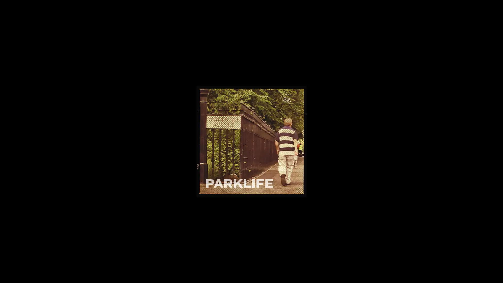 A man walks past a Woodvale Avenue sign in Parklife: A Portrait of Woodvale Park, showcasing creative brand photography and visual storytelling.