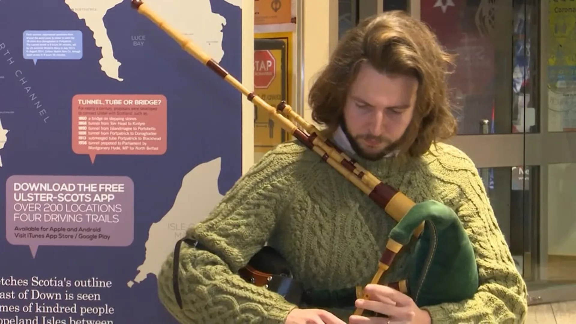 The Blackthorn Pipers: Performing at the Ulster-Scots Centre, featuring a musician in a green cable-knit sweater playing traditional bagpipes.