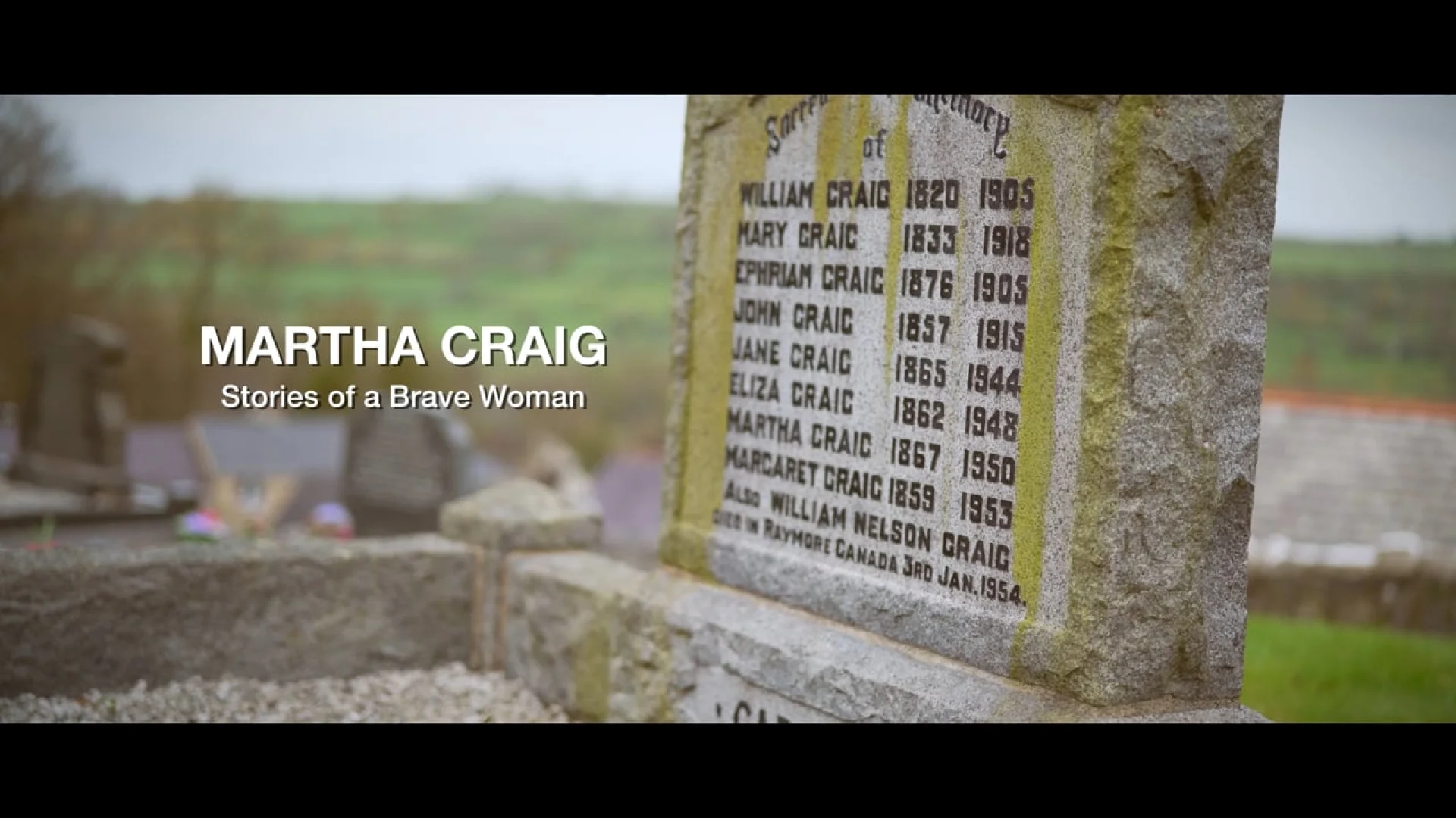 A weathered stone grave marker featuring the name Martha Craig: Stories of a Brave Woman, set against a soft-focus rural cemetery background.