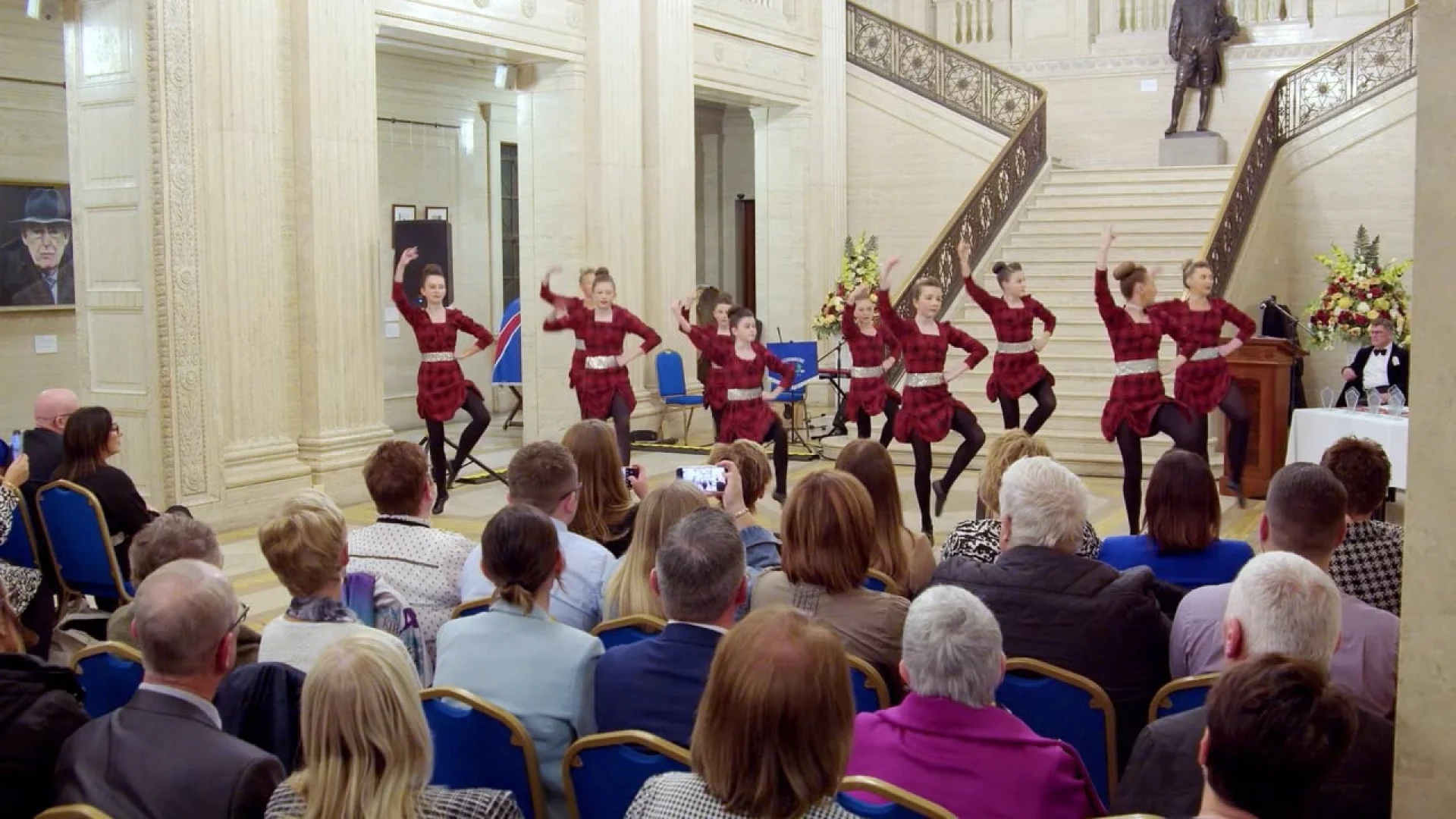 Dancers in plaid dresses perform at an event featured in Ulster-Scots Voices: Episode Two, showcasing cultural brand strategy and storytelling.