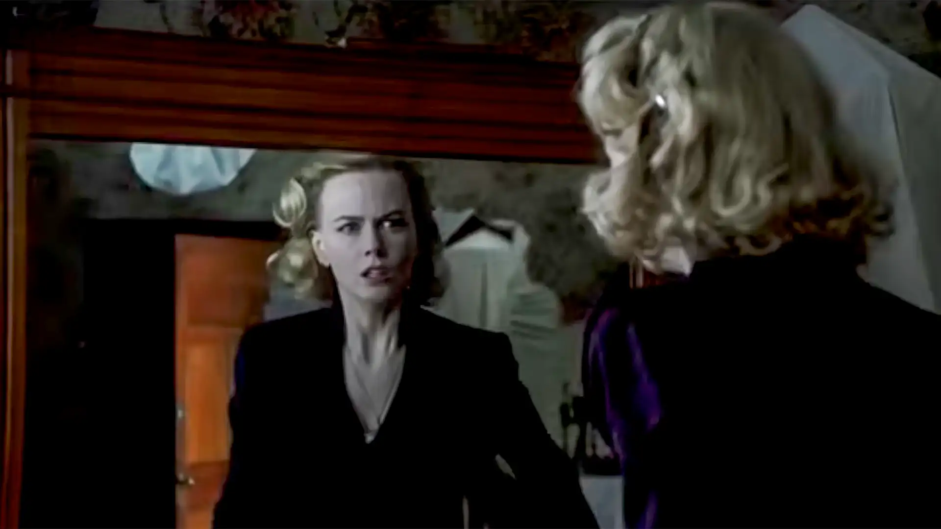 A woman with blonde hair in a dark outfit looks into a mirror, featured in Banterflix: 23rd October 2026, highlighting cinematic brand storytelling.