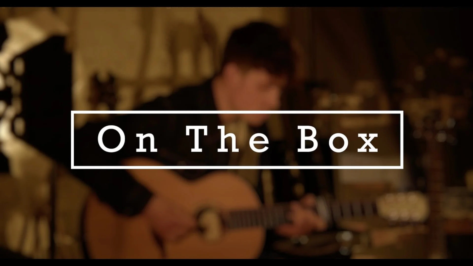 Ben Cutler performing in a warm, dimly lit studio with the text On The Box overlaid, highlighting creative brand development and musical strategy.