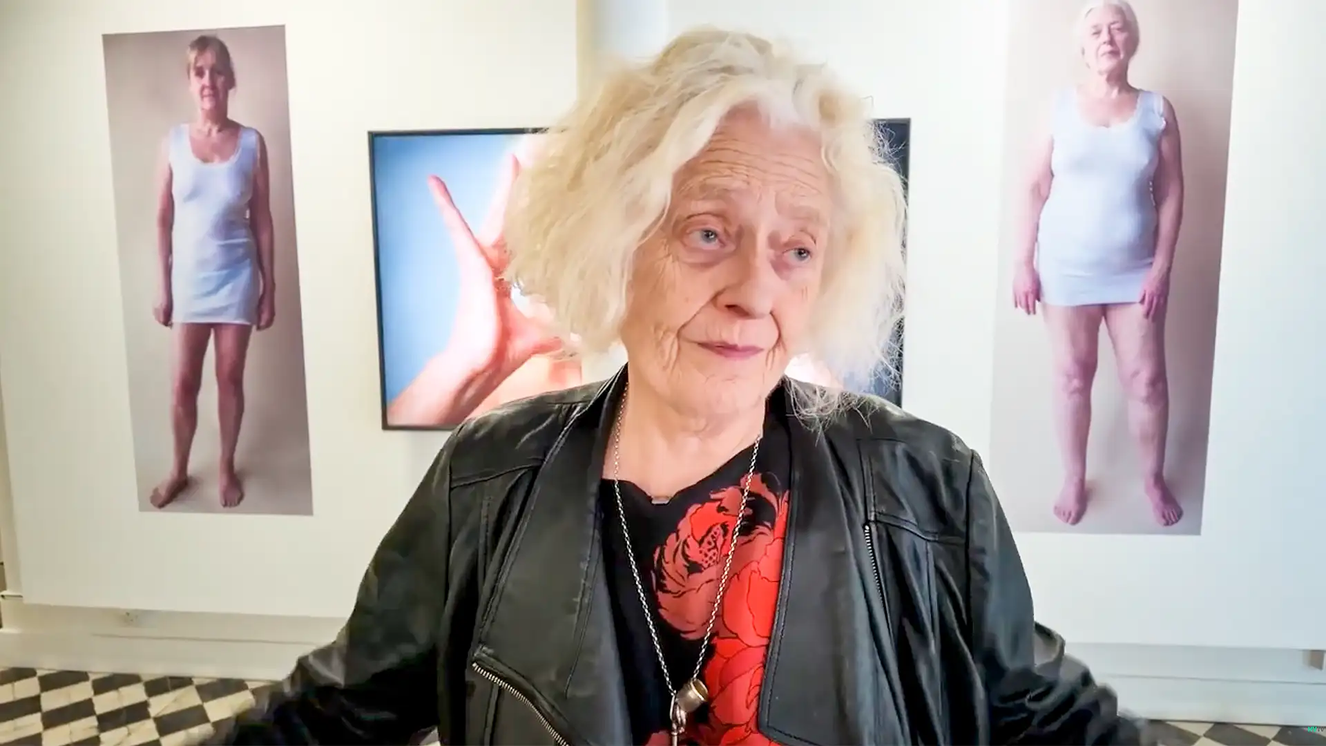 Rosy Martin: Act of Becoming | Art, Ageing, Identity & Memory at Belfast Exposed, featuring the artist in front of her portrait photography exhibit.