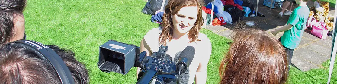 A volunteer being interviewed on camera for an RVbrand strategy project, set in a sunny outdoor park.